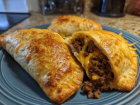 Close-up of golden brown air fryer beef chimichangas, one cut open showing seasoned ground beef and melted cheese filling.
