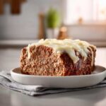 A thick slice of crockpot french onion meatloaf topped with melted white cheese.