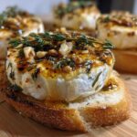 A close-up of one of the amazing goat cheese and honey bites served warm on toasted baguette slices.