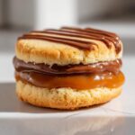 A single, delicious twix cookies sandwich made of shortbread, thick caramel, and drizzled with chocolate.