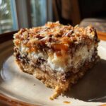 A square slice of magic cookie bars showing layers of crust, chocolate, white filling, and toasted coconut and pecans on top.