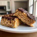 Two delicious, thick homemade protein bars made with oats and topped with drizzled dark chocolate.