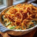 Close-up of a creamy green bean casserole topped generously with crispy fried onions.