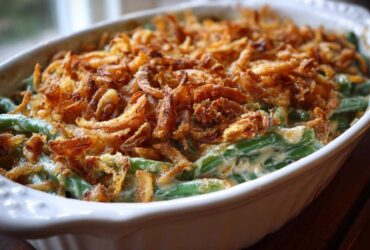 Close-up of a creamy green bean casserole topped generously with crispy fried onions.