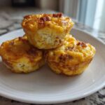 Three golden-brown cottage cheese egg cups starbucks style stacked on a white plate.