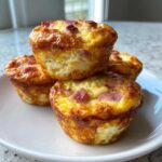 A stack of four golden-brown cottage cheese egg cups starbucks style on a white plate.