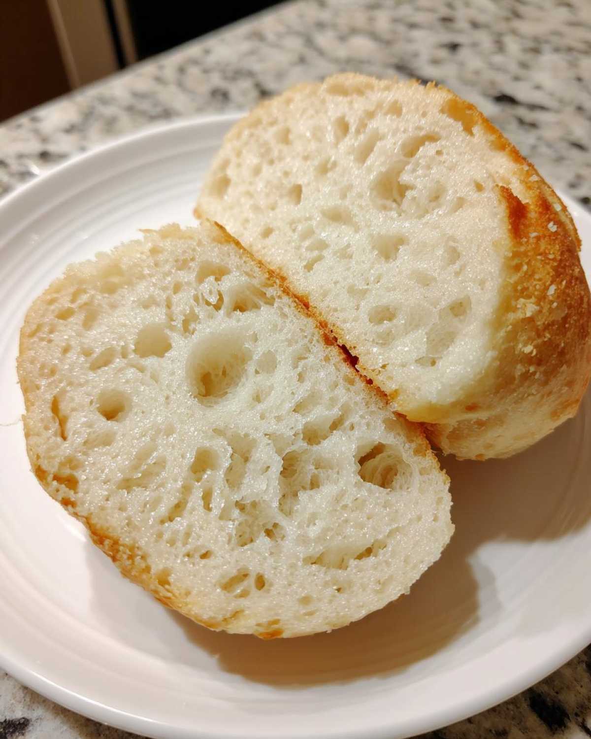 Close-up of an english muffin cut in half showing the porous, airy interior texture.