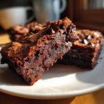 Close-up showing the fudgy interior texture of sweet potato brownies topped with chocolate chips.