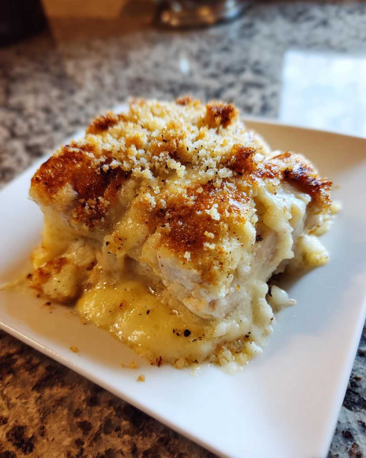 A close-up of a serving of creamy Garlic Parmesan Chicken Bake topped with golden brown breadcrumbs.