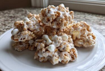 A pile of freshly made avalanche cookies drizzled with white chocolate and topped with mini marshmallows.