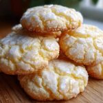 A stack of soft, yellow Italian ricotta cookies topped with a white, crinkled lemon glaze.
