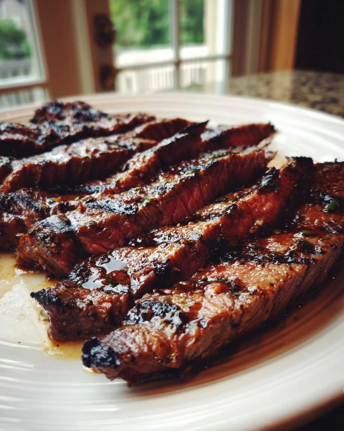 Close-up of perfectly grilled and sliced steak glistening with juices, prepared with carne asada marinade.