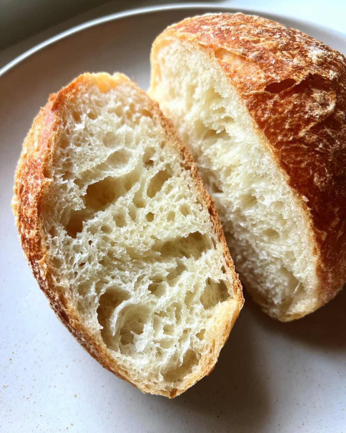 Close-up of a low-calorie english muffin cut in half showing the airy, open crumb structure.