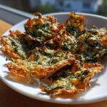 Close-up of golden brown, crispy Mediterranean Spinach and Feta Cheese Crisps on a white plate.