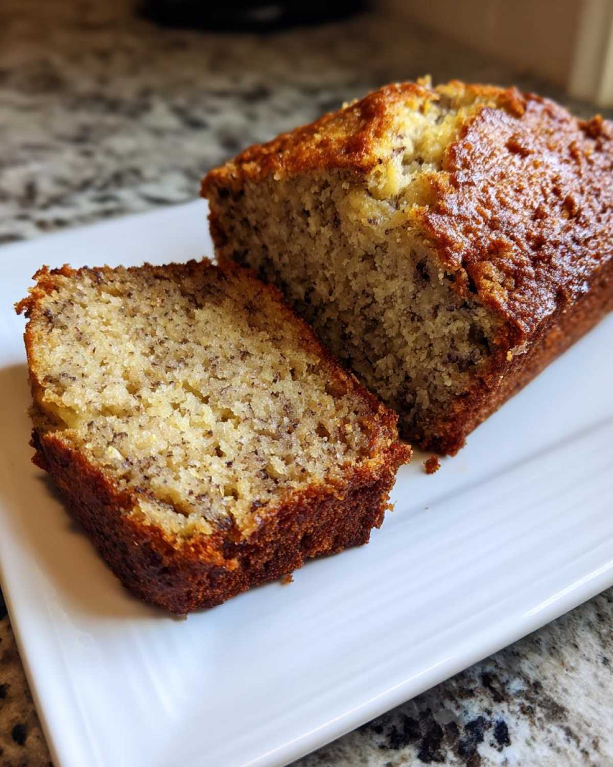 Close-up of a moist banana bread loaf, sliced to show the tender crumb texture.