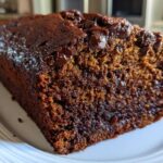 Close-up of a moist slice of rich, dark chocolate banana bread studded with melted chocolate chips.