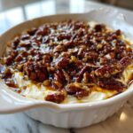 Close-up of a creamy, no-bake pecan pie dip topped generously with glazed, candied pecans.