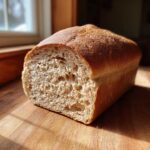Close-up of a freshly baked loaf of whole wheat bread, showing the soft, airy crumb texture.