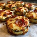 Close-up of freshly baked zucchini pizza bites topped with melted, browned cheese and pepperoni slices.