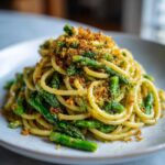 Close-up of a mound of Asparagus Lemon Pasta with Parmesan Crumbs, featuring bright green asparagus and golden breadcrumbs.
