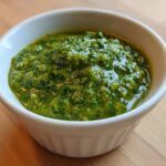 Close-up of vibrant green Avocado Tomatillo Salsa Verde served in a small, white, ribbed bowl.