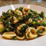 Close-up of Orecchiette pasta tossed with vibrant green Broccoli Raab Pasta with Chili Flakes.