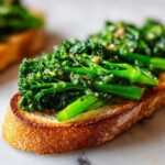 Close-up of vibrant green Broccolini Garlic Anchovy Toast on toasted bread.