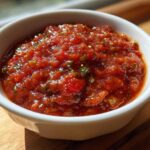Close-up of vibrant, chunky Fire-Roasted Tomato Salsa Roja served in a small white bowl.
