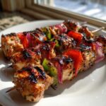 Close-up of perfectly grilled Tequila Lime Chicken Skewers featuring charred chicken, red peppers, green peppers, and red onion.