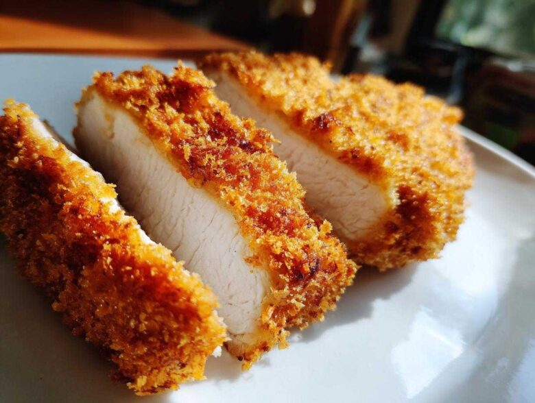 Close-up of three thick slices of golden brown Katsu Curry Sandwich Cutlets showing juicy white meat inside.