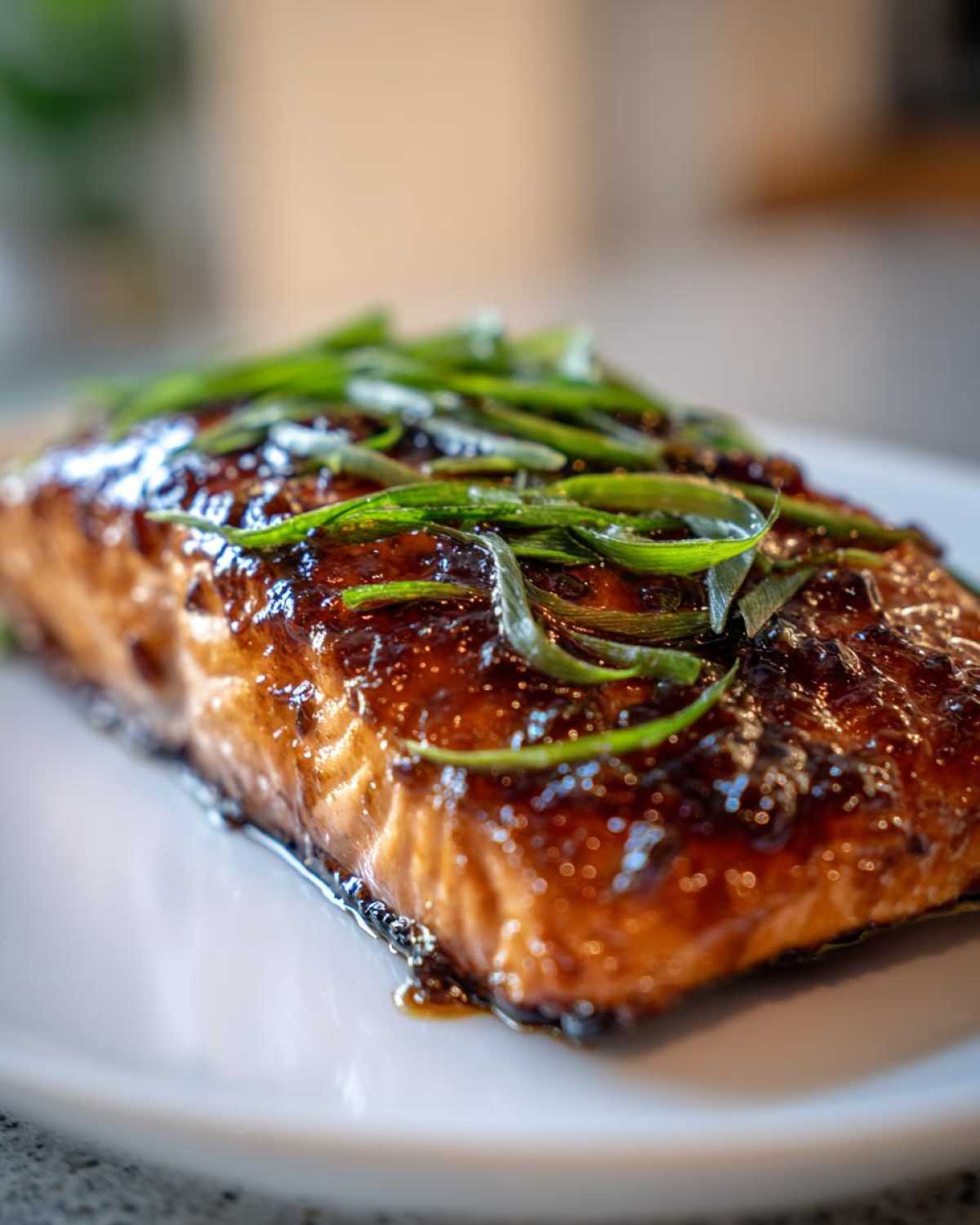 Close-up of a perfectly cooked Miso Glazed Salmon with Scallions, featuring a dark, shiny glaze.
