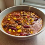 Close-up of a hearty bowl of One-Pot Taco Soup with Lime, featuring ground meat, kidney beans, and corn in a rich broth.