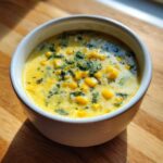 A close-up of a bowl of creamy Poblano Corn Chowder with cilantro sprinkled on top.
