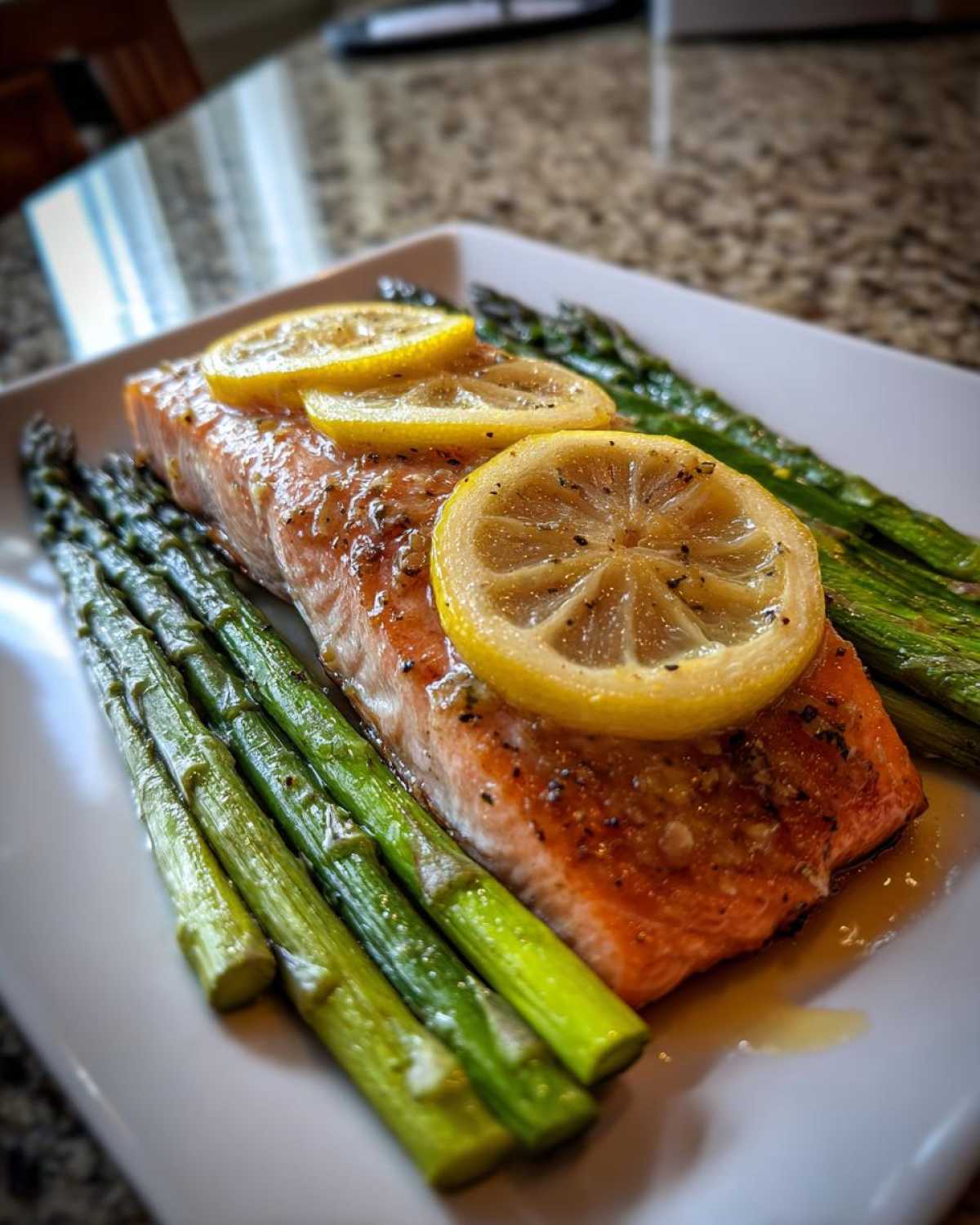 Close-up of a perfectly cooked Sheet-Pan Salmon with Asparagus, topped with lemon slices.
