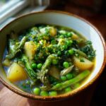 A close-up of a hearty bowl of Spring Vegetable Minestrone Soup featuring asparagus, peas, and potatoes.