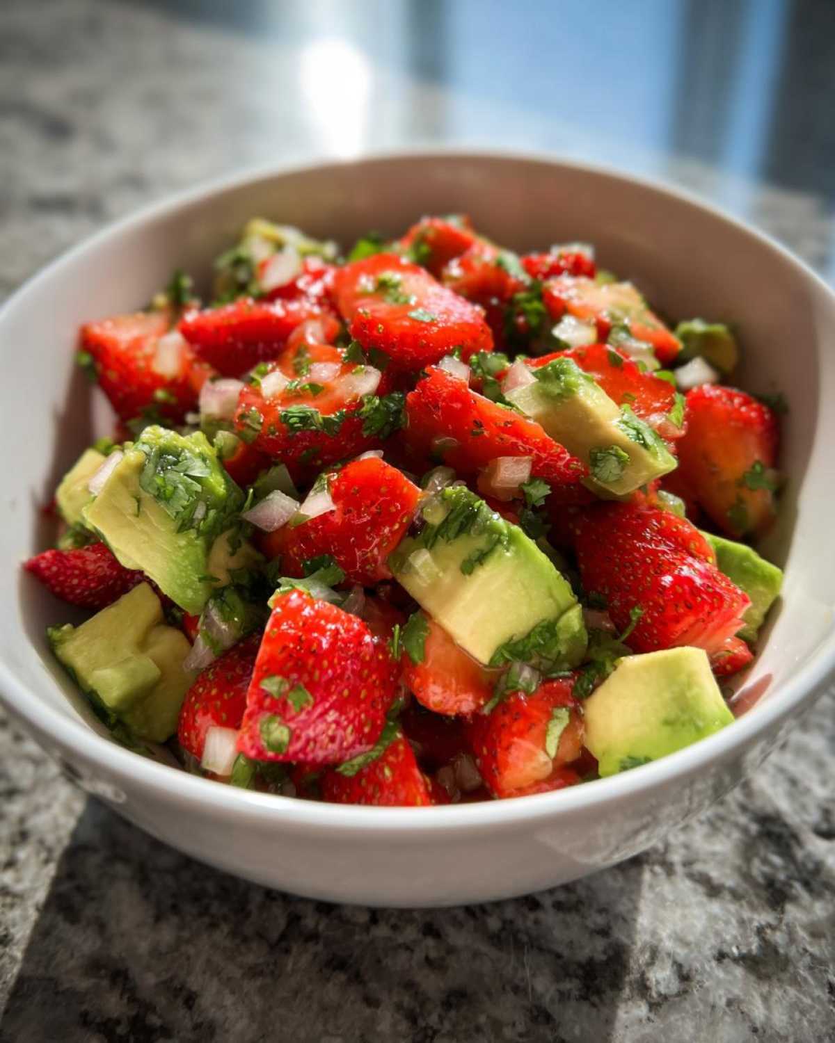 Close-up of fresh Strawberry Avocado Salsa with Lime, featuring diced strawberries, avocado chunks, and cilantro in a white bowl.