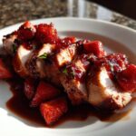 Close-up of sliced Strawberry Balsamic Pork Tenderloin covered in a rich, glossy strawberry balsamic reduction.